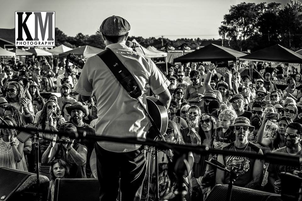 Musician performing at outdoor festival with crowd