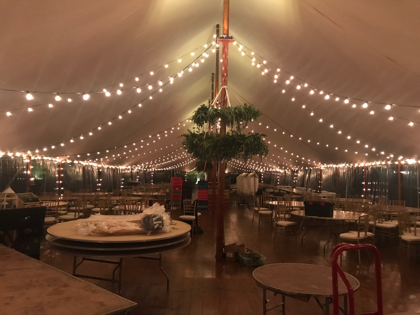 Festive tent interior with warm string lights and greenery